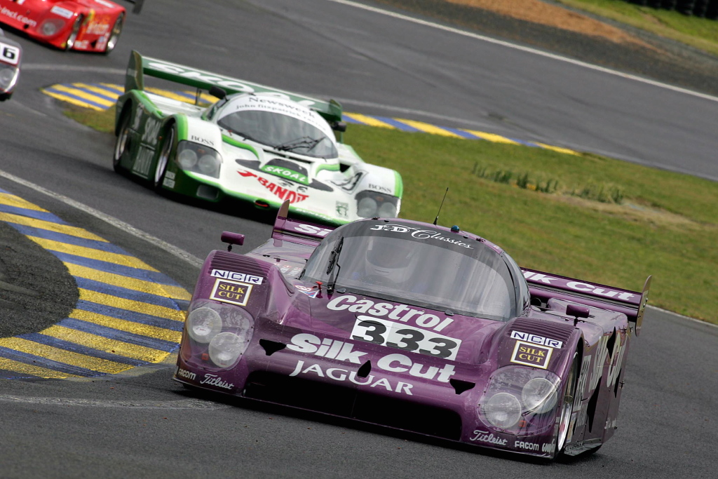 Two classic prototype cars racing at Le Mans